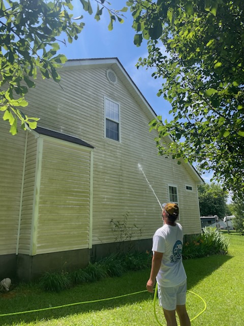 House washing before and after in Jacksonville, NC: mildew streaked vinyl siding being soft washed