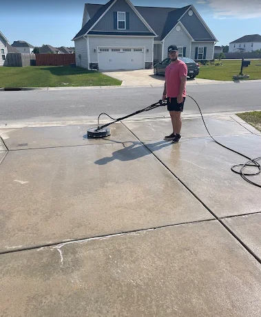 Keep It Clean Pressure Washing owner cleaning a concrete driveway in Jacksonville, NC